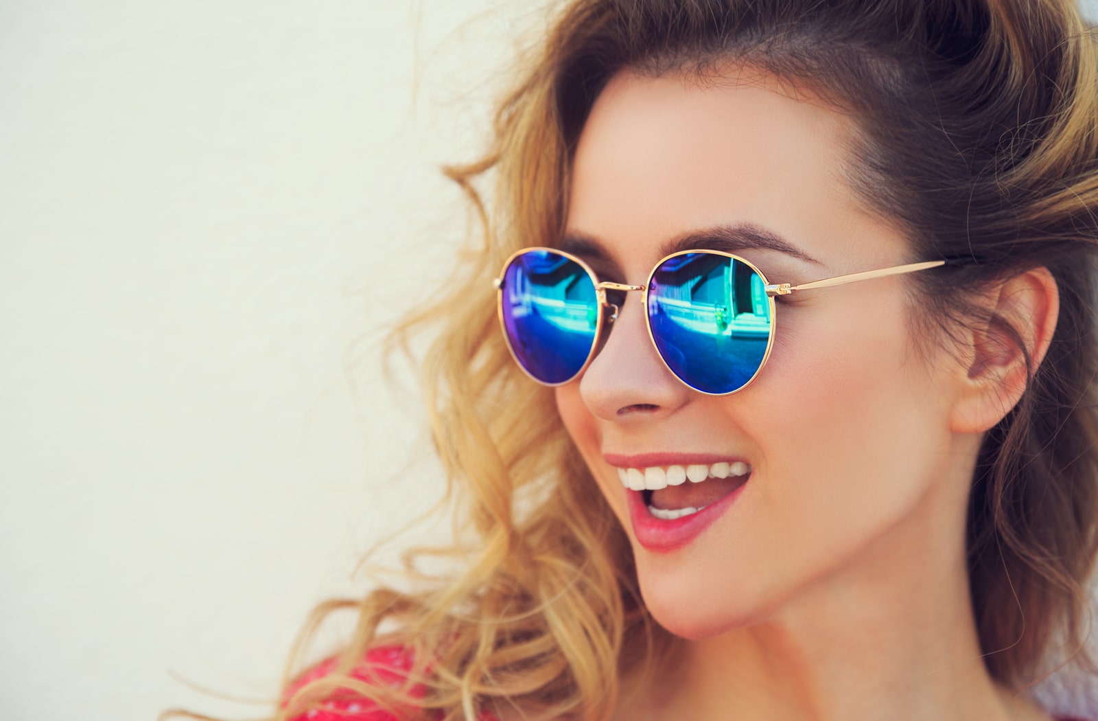 A smiling woman wearing a pair of polarized sunglasses