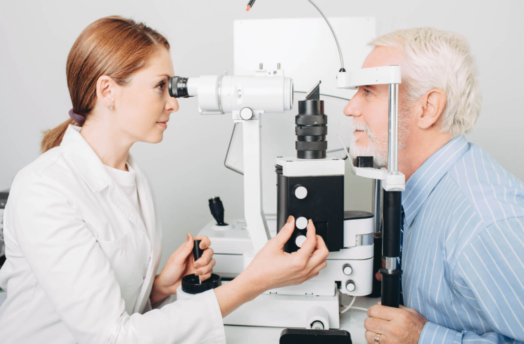 A senior man and his optometrist's performing an eye examination using a machine to detect any eye problems.