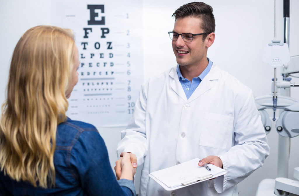 A woman in an optometry clinic shaking hands with a male optometrist.