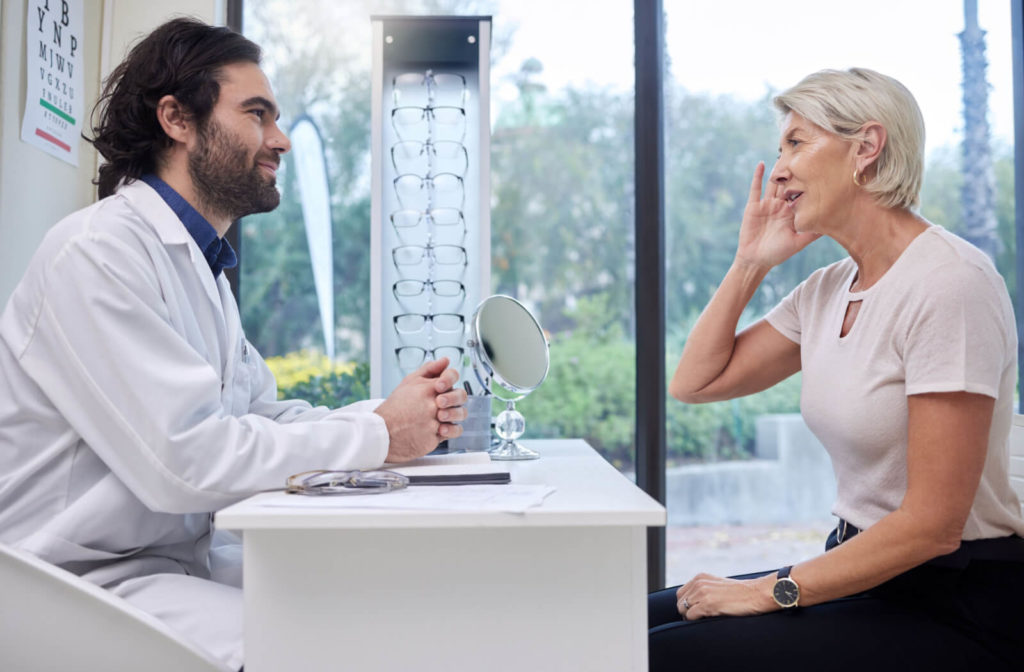 An optometrist talking to his patient in an optical clinic