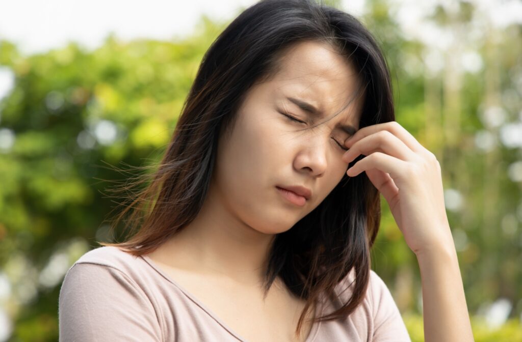 A person experiencing eye irritation due to environmental factors
