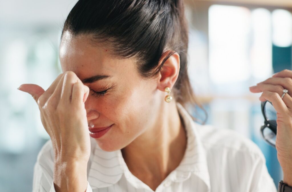 A women pressing her hand against her face due to eye pain.