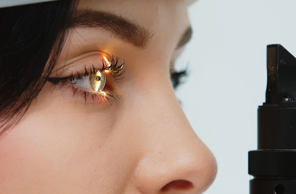 A close up of a person having their eyes examined with a slit lamp during an eye exam at the eye doctor's office.