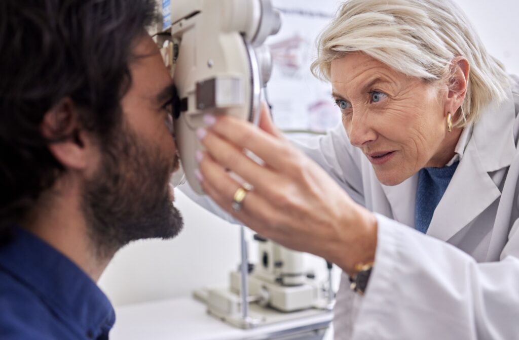 An optometrist using a phoropter during a comprehensive eye exam.